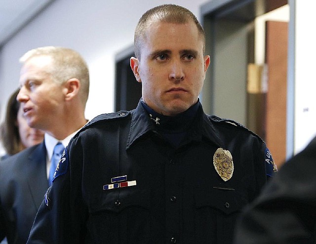 Aurora police officer Justin Grizzle leaves court after testifying at a preliminary hearing for James Holmes at the courthouse in Centennial, Colo., on Monday. Grizzle fought to keep his composure during his testimony, in which he described wounded people trying to run and crawl away from the theater.

