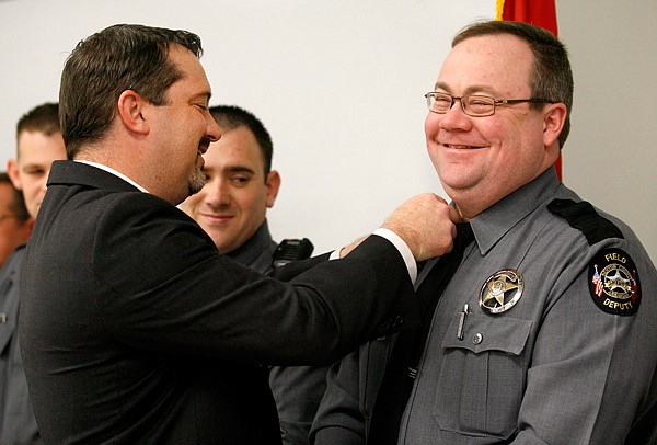 Benton County Sheriff Kelley Cradduck, left, pins new bars onto the collar of Patrol Lt. Randy Allsup during a promotion ceremony on Monday inside the Benton County Sheriff’s Office in Bentonville. 
