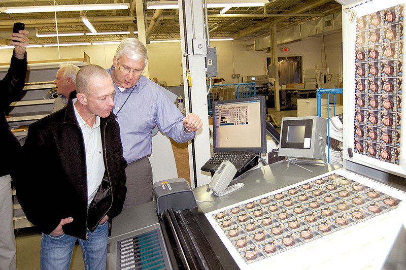 Veteran jockey Carl Borel, left, and Steve Arrison, CEO of Visit Hot Springs, look over a printed sheet that will become trading cards celebrating Borel’s 5,000th victory of his career. As many as 30,000 of the special trading cards will be given out at Oaklawn Park on the day Borel rides to his milestone vistory as only the 25th rider to achieve 5,000 wins in thoroughbred horse racing.
