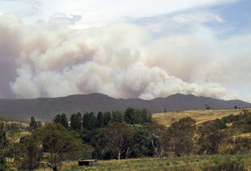 Wildfire smoke rises from hills near the village of Numeralla in New South Wales state on Tuesday, Jan. 8, 2013. Wildfires raged across much of southeast Australia.
