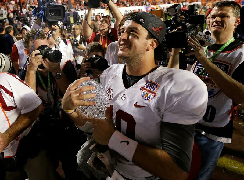 Alabama quarterback AJ McCarron holds The Coaches’ Trophy after the Crimson Tide won their second consecutive BCS national championship with a 42-14 victory over Notre Dame on Monday. 