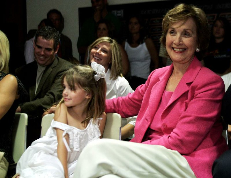 FILE - In this Friday, May 19, 2006, file photo, Patsy Sutton, right, wife of then-Oklahoma State men's basketball coach Eddie Sutton, smiles as she sits with granddaughter Hallie Sutton, left, as she listens to her husband give his resignation speech during a news conference in Stillwater, Okla. Patsy Sutton, 74, died Tuesday, Jan. 8, 2013, at a Tulsa, Okla., hospital, officials at Ninde Brookside Chapel say. (AP Photo/File)