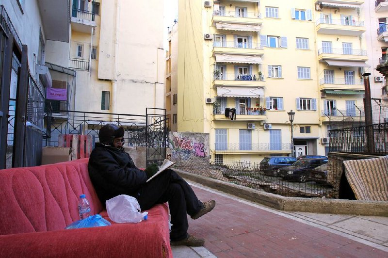 A homeless man sits on a sofa Monday in the northern port city of Thessaloniki, Greece. Eurozone unemployment rose to 11.8 percent in November, Eurostat said Tuesday. 