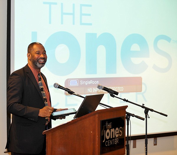 Cory Anderson, with the Winthrop Rockefeller Foundation, addresses the crowd as they get ready for a live stream press conference from Little Rock to begin Tuesday morning at the Jones Center in Springdale. The press conference announced the release "A Profile of Immigrants in Arkansas 2013", a three-volume report that analyzes key demographic trends and the economic impact of immigrants and the Marshallese population in Arkansas.