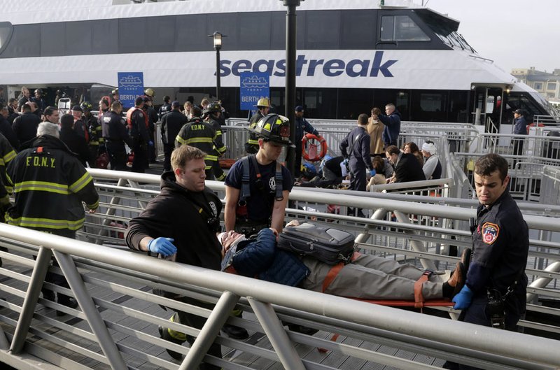 New York City firefighters remove an injured passenger of the Seastreak Wall Street ferry, in New York, Wednesday, Jan. 9, 2013. The Seastreak Wall Street ferry from Atlantic Highlands, N.J., banged into the mooring as it arrived at South Street in lower Manhattan during morning rush hour, injuring as many as 50 people, at least one critically, officials said.