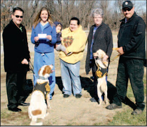 Holly Beeman (second from left) presented at check for $1,205 to Gentry Mayor Kevin Johnston (left) to pay for heat lamps in each of the 10 kennel areas at the Gentry dog impoundment facility on Friday. Pictured with Johnston and Beeman are Tailwaggers treasurer Priscilla Dorado and nephew Dason Costa, secretary Laura Lewis, and Gentry animal control officer Skip Paczowski. Also pictured are two of the dozen or more dogs at the shelter awaiting adoption. 