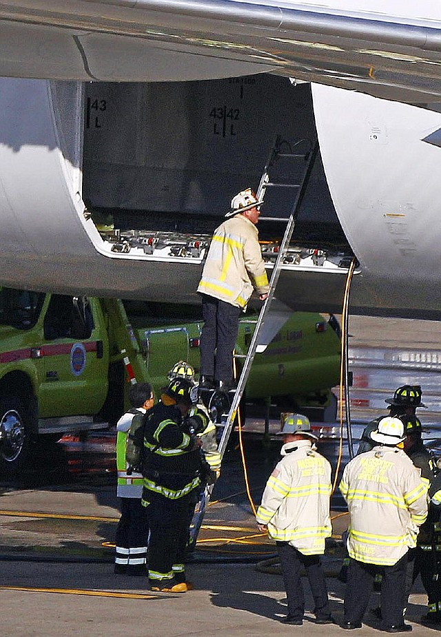 A Boston Fire Department chief looks into the cargo hold of a Japan Airlines Boeing 787 Dreamliner jet parked at a Terminal E gate at Logan International Airport in Boston, Monday, Jan. 7, 2013. A small electrical fire filled the cabin of the JAL aircraft with smoke Monday morning about 15 minutes after it landed in Boston. (AP Photo/Stephan Savoia)