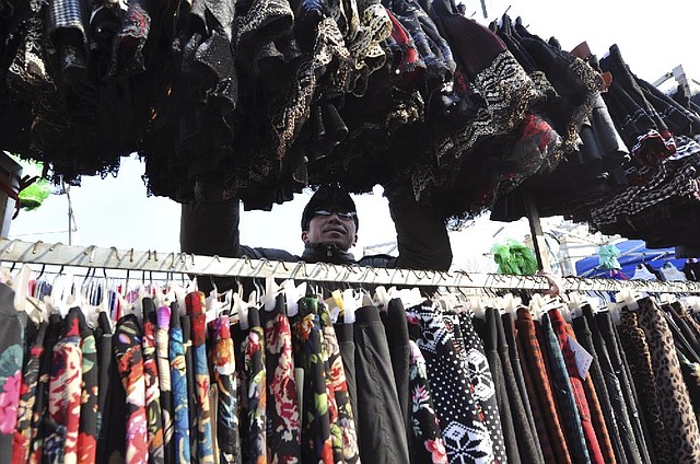 A vendor arranges clothes Wednesday at a market in rural Zouping County in eastern China. China’s trade growth rebounded in December, the government said. 