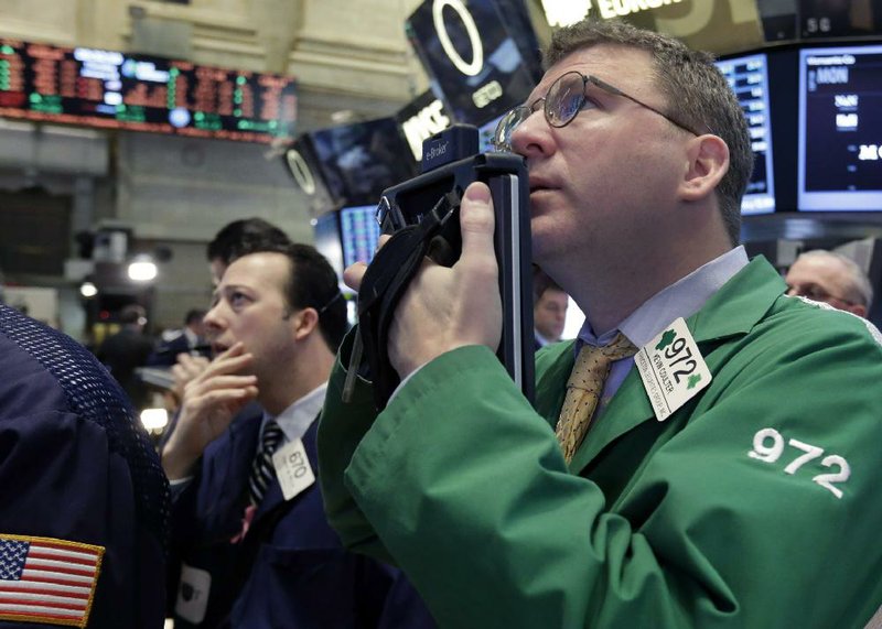 Trader Kevin Coulter (right) works Thursday on the floor of the New York Stock Exchange where the Standard and Poor’s 500 closed up 11.10 points to 1,472.12. 