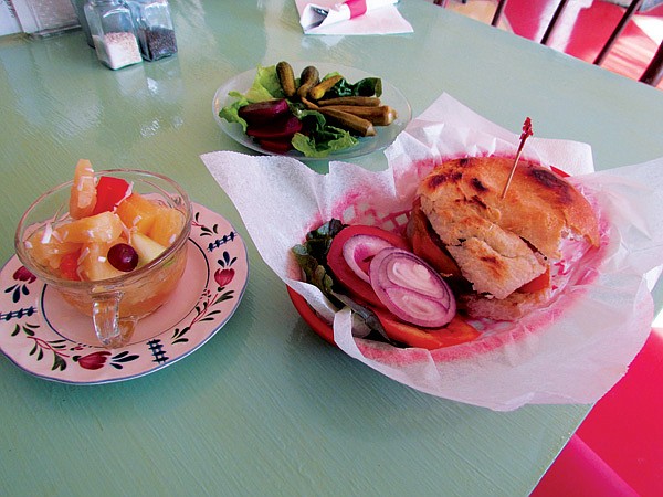 The Red Hen Bakery & Cafe’s most popular item is the Red Hen Burger, which is shown here with fruit salad and a pickle plate. 