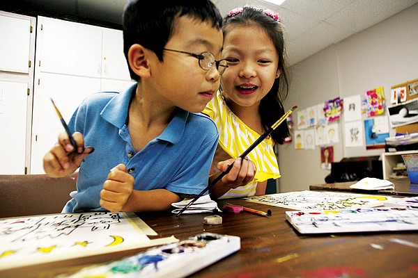 Torrie Pianalto, left, and Sophia Flores, both of Springdale, share a paint palette at the Arts Center of the Ozarks in Springdale. Art classes start in January. 