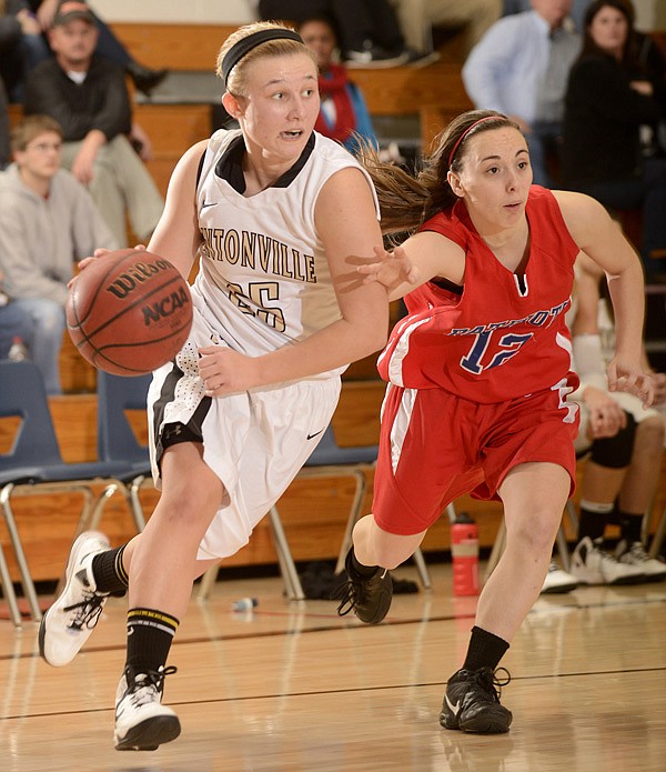 Bentonville’s Deanna Adkins, left, shown driving past East Newton (Mo.) defender Shelbey Thomlinson during the 58th annual Neosho (Mo.) Holiday Classic, provides the Lady Tigers with instant offense off the bench. 