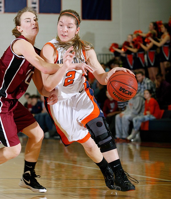 Ashley Ward, a Rogers Heritage senior, tries to drive Tuesday around Springdale High senior Brittany Jurgens at War Eagle Arena in Rogers. 