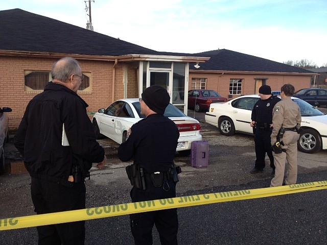 Police talk Friday morning at the scene where two people were killed and one injured in a shooting in Greenland.