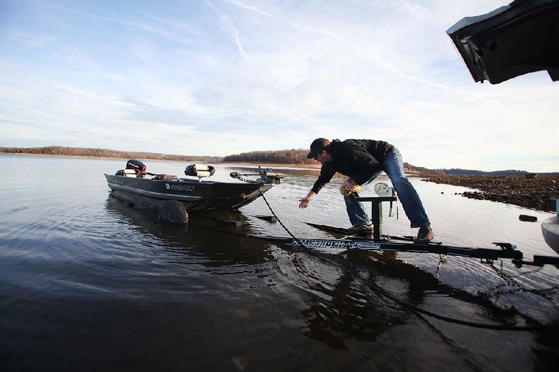 Arkansas Democrat-Gazette/RYAN MCGEENEY --01-11-2013-- Chris McClinton of Fayetteville eases his fishing boat off a trailer Friday morning into Beaver Lake near Rogers. The lake is presently at about 67 percent of its total capacity short of flooding. 