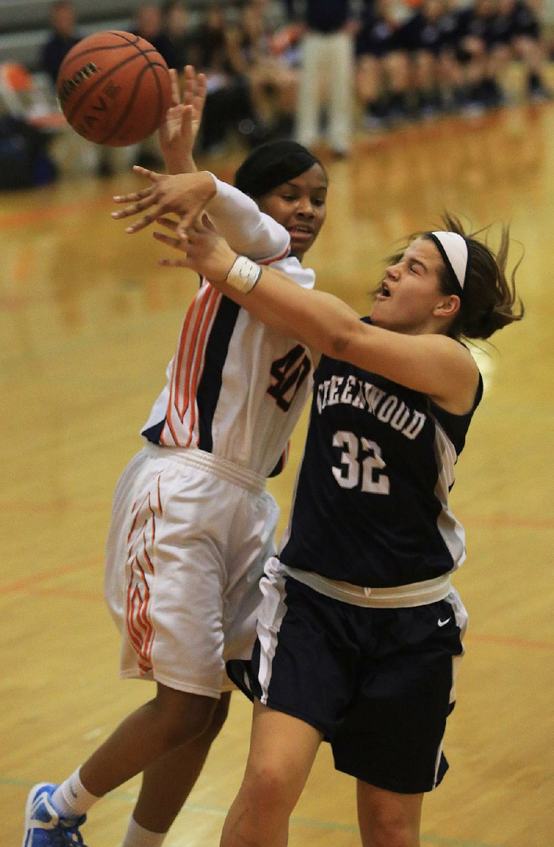 Little Rock Hall’s Tiarra Coffey (40) blocks a shot by Greenwood’s Megan Hartness (32) during Friday’s game in Little Rock. Coffey ÿnished with 15 points and nine rebounds for the Lady Warriors as they won 52-45. 