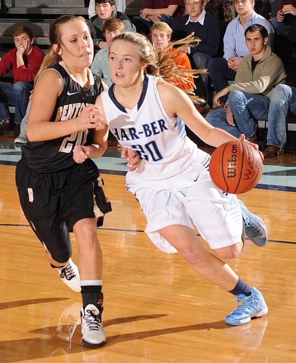 Brooke Mabeus, right, of Bentonville heads toward the basket Friday as Rogers Heritage’s Ellen Lundy tries to defend at Rogers Heritage in Rogers. 