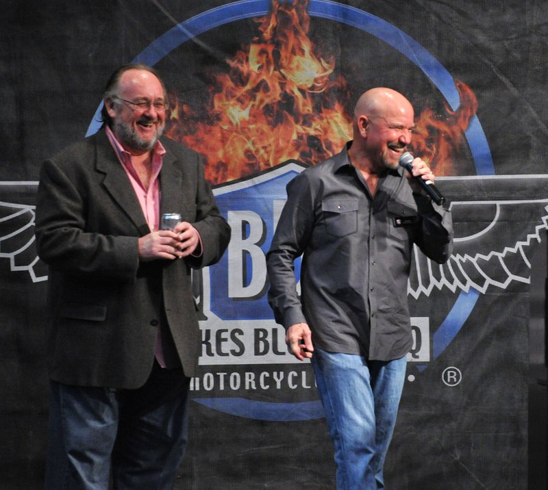 Ken Mourton, left, chairman of the Bikes Blues & BBQ rally, and Joe Giles, its executive director, address the audience Friday evening at the Fayetteville Town Center during an event celebrating the organizations charitable contributions to 28 local charities.
