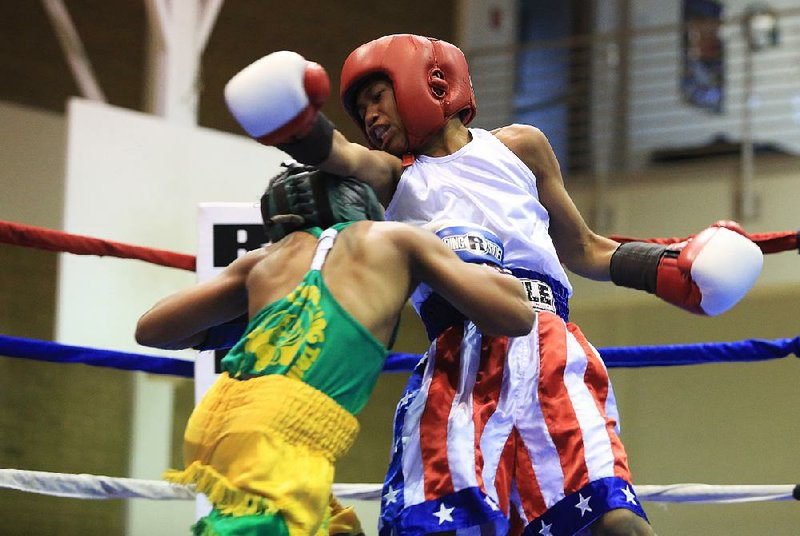 Dezmon Carpenter (right) of Tennessee misses with a straight right over the top of California’s Alyza Martin (left) during their championship bout Saturday. Carpenter connected enough to defeat Martin in the 90-pound division at the Region 6 Silver Gloves tournament at the North Little Rock Community Center. 