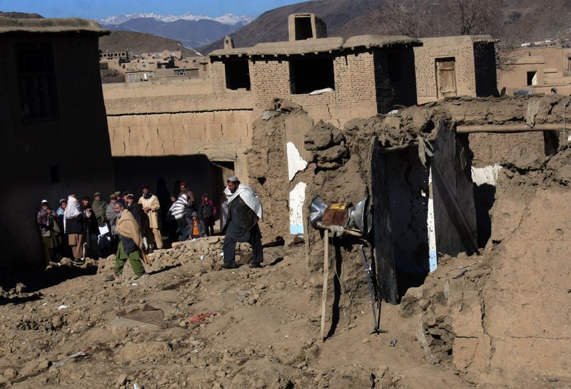 Afghans stand near a damaged mosque following an explosion in Sayedabad, Wardak southwest of Kabul, Afghanistan, Sunday, Jan. 13, 2013. An explosion killed seven Afghan villagers Sunday as they tried to pull bodies of insurgents killed from the rubble of a village mosque after a night raid by NATO and Afghan troops in the country's east, officials said. Four insurgents and an Afghan soldier were also reported to have been killed. 