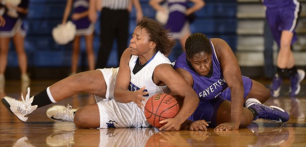 Taylor Strickland, left, Rogers High, battles for a loose ball Friday with Fayetteville’s Brittany Austin at King Arena in Rogers. 