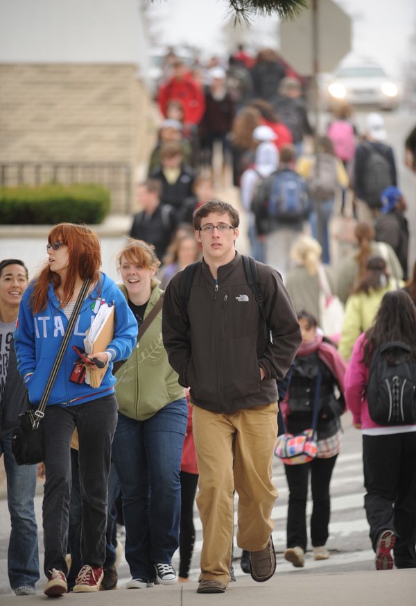 University of Arkansas students cross West Dickson Street in Fayetteville during a class change. A legislative committee recommended last month Arkansas Lottery scholarship amounts be cut to $3,300 a year per student from $5,000 at the state’s four-year universities and $1,650 a year from $2,500 at two-year colleges for first-time recipients. 
