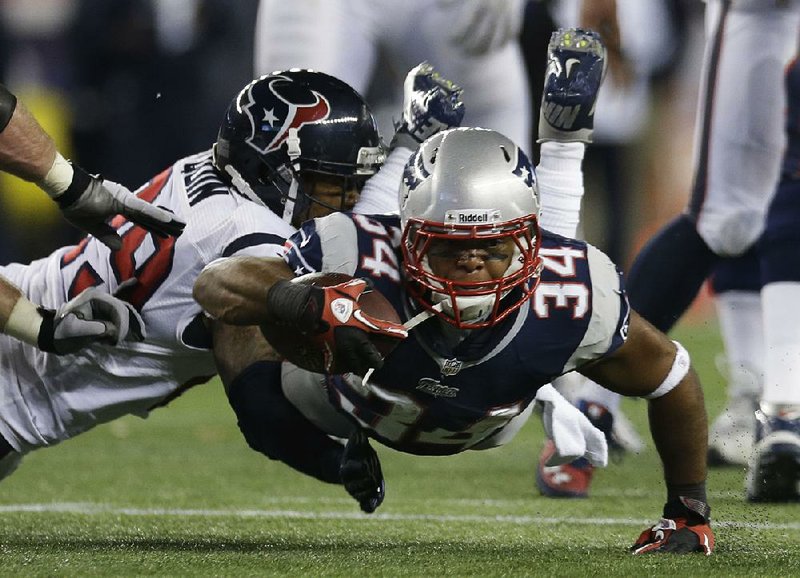New England Patriots running back Shane Vereen (34) dives forward as he is tackled by Houston Texans safety Glover Quin during the first half of Sunday’s game in Foxborough, Mass. 