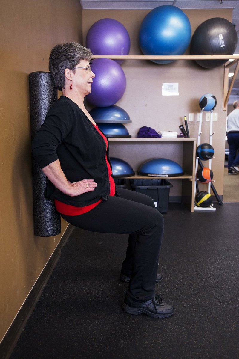 Linda Walker does a mostly isometric exercise, the wall squat, but adds the twist of trying to march her feet sideways without letting the foam roller get away from her — which is much harder than it looks. 