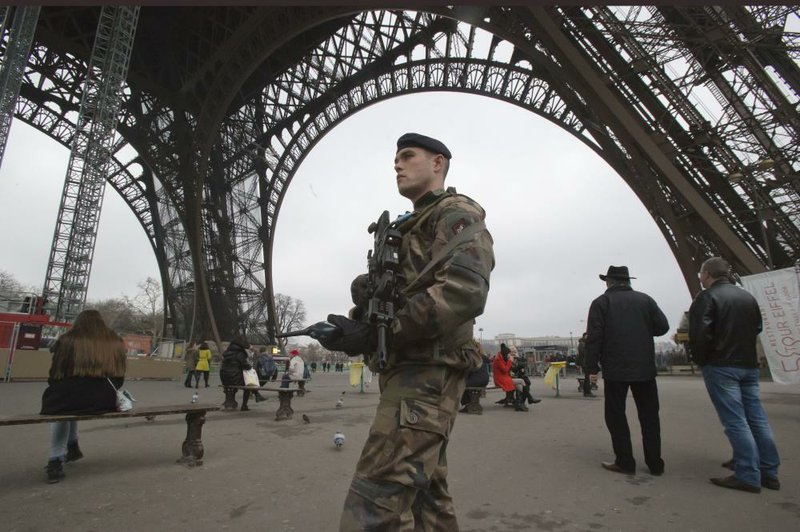 A French soldier patrols under the Eiffel Tower on Sunday in Paris. France has ordered tightened security in public buildings and transport after action against radical Islamists both in Mali and Somalia. 