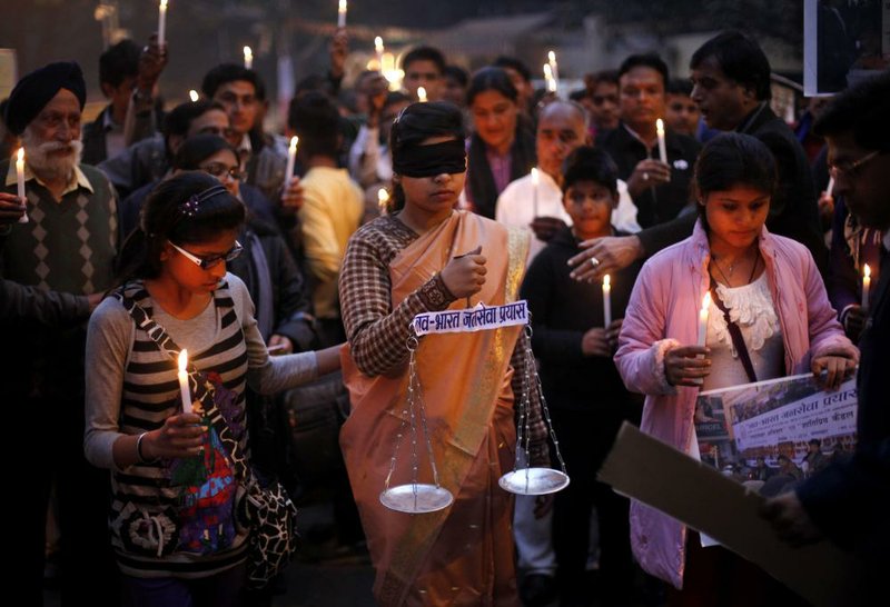 An Indian girl dressed as Lady Justice participates in a candlelight vigil Sunday in New Delhi. 