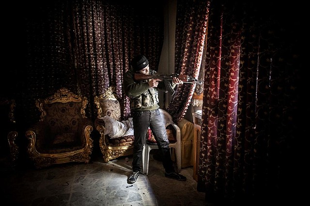 A Free Syrian Army fighter aims his gun in the Saif al-Dawlah neighborhood of Aleppo, Syria, on Sunday. 