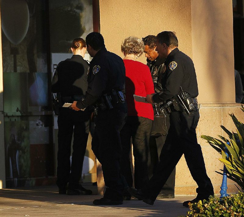 Police officers talk to a witness near a shooting at the Reading Cinemas on Saturday in San Diego. 