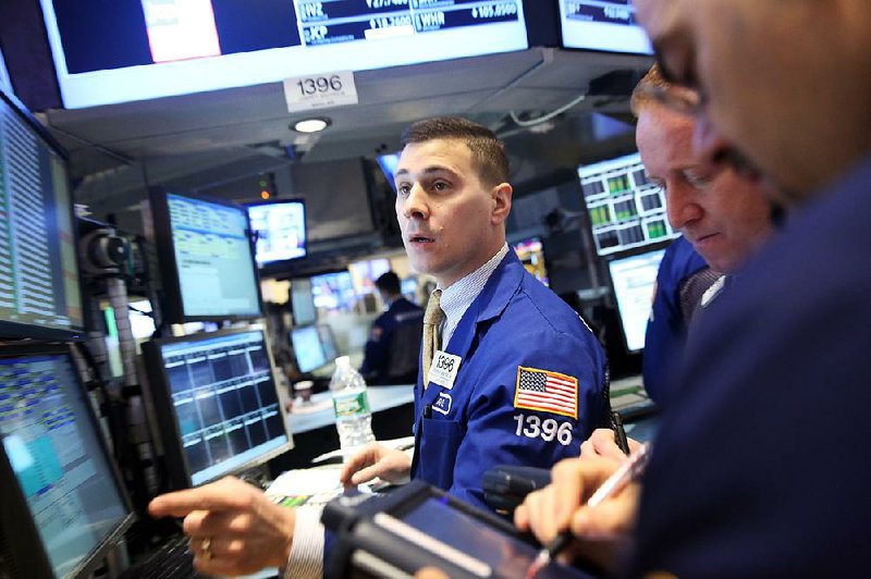 Traders work Monday on the floor of the New York Stock Exchange. A drop in Apple Inc. shares held down the Standard & Poor’s 500 index on Monday. 