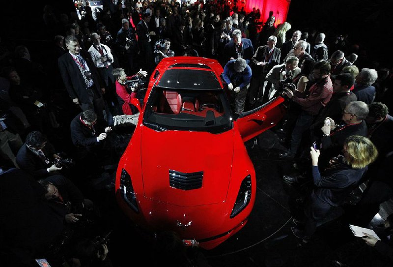 Journalists surround General Motors’ new 2014 Chevrolet Corvette Stingray at the North American International Auto Show on Sunday in Detroit. 