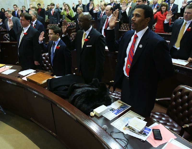 State Reps. (from left) John Baine, Warwick Sabin, Monte Hodges and Fred Smith take the oath of office in the House chambers at the state Capitol on Monday in Little Rock. 