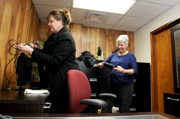 Joanna Maddox, professional development assistant for the Springdale School District, left, and Uni de la Teja, federal programs assistant for the district, organize de la Teja’s office Monday at the district’s new professional development building in Springdale. 