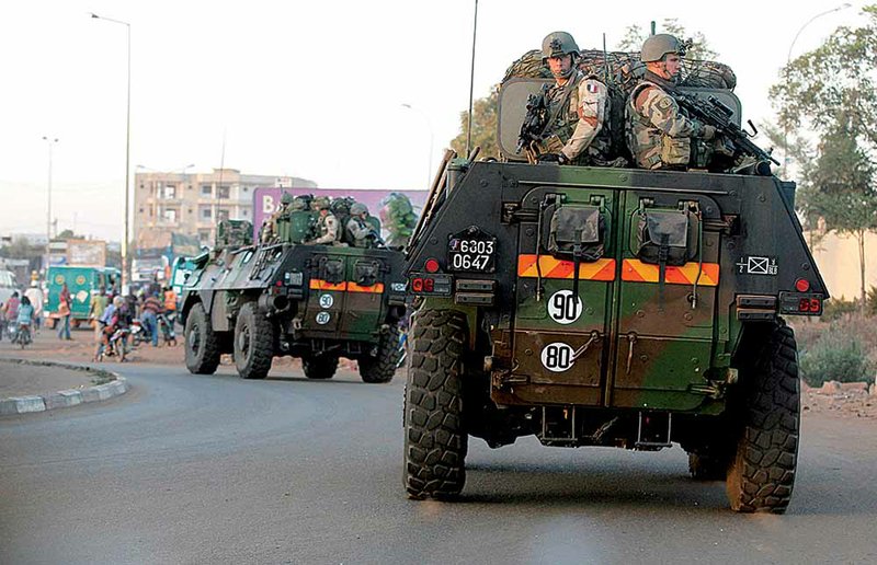French soldiers pass through Bamako, Mali’s capital, in armored personnel carriers Tuesday. 