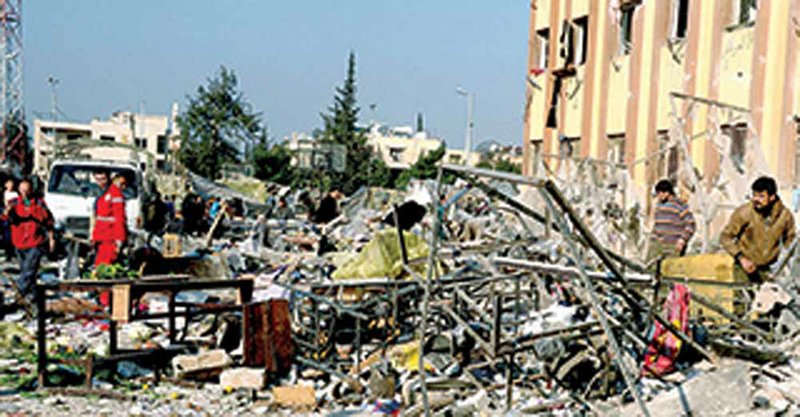 Syrians gather at the site of an explosion Tuesday at a university in Aleppo, Syria, in this photo released by Syria’s official news agency, SANA. 