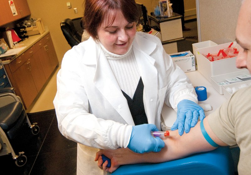 Trish Calhoun prepares to draw blood from one of the airmen at the Little Rock Air Force Base. Calhoun, a lab tech at the base, recently started a support group for people with autoimmune disorders. She was diagnosed with lupus.