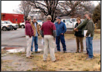 Representatives from the city of Gravette, the Arkansas Highway Department, a landscaping firm, and an engineering firm discuss a highway intersection beautification project in Gravette. 
