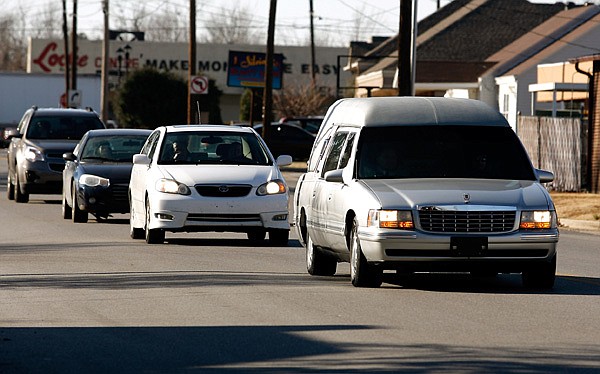 A funeral procession moves east Wednesday along West Meadow Avenue from Sisco Funeral Chapel in Springdale. Because of manpower and liability issues, Springdale police will no longer provide escorts for funeral processions. 