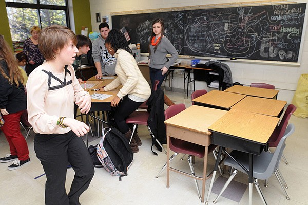 Emily Poole, left, moves to lock and cover the classroom door Wednesday as her third-period class moves to the west side of the room during a lockdown drill at Fayetteville High School. Superintendent Vicki Thomas said the drills are required for all Fayetteville schools once a semester. 