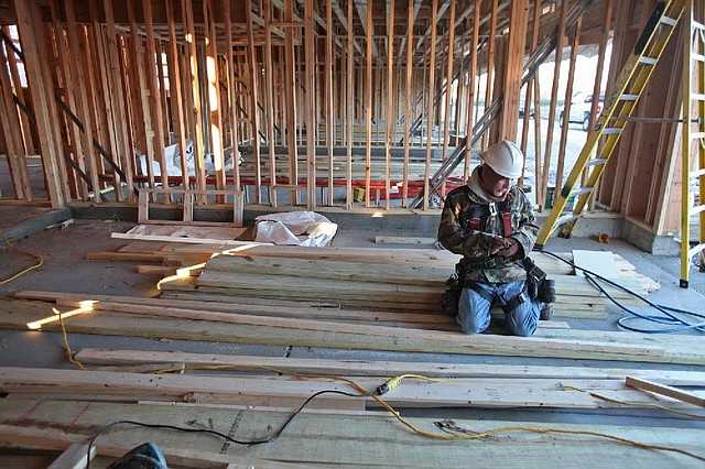 A carpenter works on a new town house in Des Plaines, Ill., on Monday. Home construction jumped in December, the Commerce Department said Thursday. 