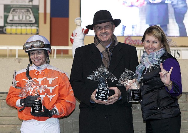 Texas Bling owner Lewis Hall (center), trainer Danele Durham (right) and jockey Erik McNeil show off their trophies after McNeil guided the 2-year-old long shot to victory in the Springboard Mile last month at Remington Park in Oklahoma City. Texas Bling went off at 128-1. 