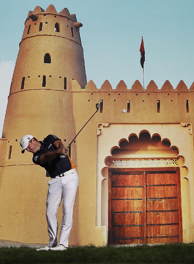 Jamie Donaldson of Wales tees off on the 15th hole in front of a poster of a castle during Thursday’s ÿrst round of the European PGA Abu Dhabi Championship. Donaldson and Justin Rose are tied at 5-under-par 67 heading into today’s second round in Abu Dhabi, United Arab Emirates.

