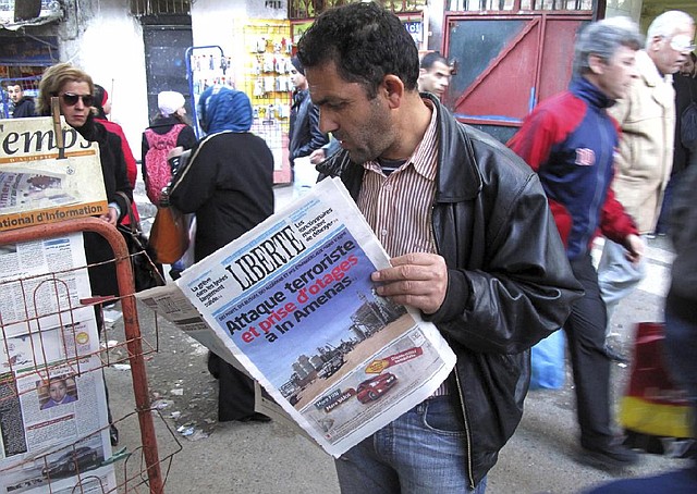 A man stands at a newsstand in Algiers on Thursday and reads a newspaper with a headline that says “Terrorist attack and kidnapping in Ain Amenas.” 