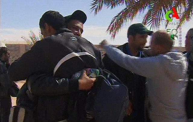 Rescued hostages hug each other in Ain Amenas, Algeria, in this image taken from television Friday. Algeria’s state news service says half of the 132 foreign hostages have been freed from a gas plant where Islamist militants had held them captive for three days. 