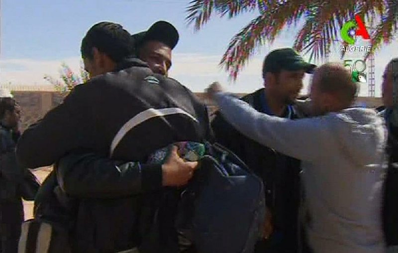 Rescued hostages hug each other in Ain Amenas, Algeria, in this image taken from television Friday. Algeria’s state news service says half of the 132 foreign hostages have been freed from a gas plant where Islamist militants had held them captive for three days. 