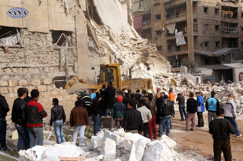 Rescue workers and bystanders gather at a building damaged Friday by a fatal rocket attack in Aleppo, Syria, in this photo released by the Syrian official news agency, SANA. 