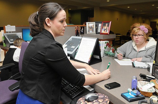 Katesha Schemerhorn, left, student records specialist, writes down information for Corinne Lawyer Thursday at NorthWest Arkansas Community College in Bentonville. Lawyer was trying to get back into an online psychology course. In December, the state released a report comparing NWACC’s finances to other two-year colleges. 